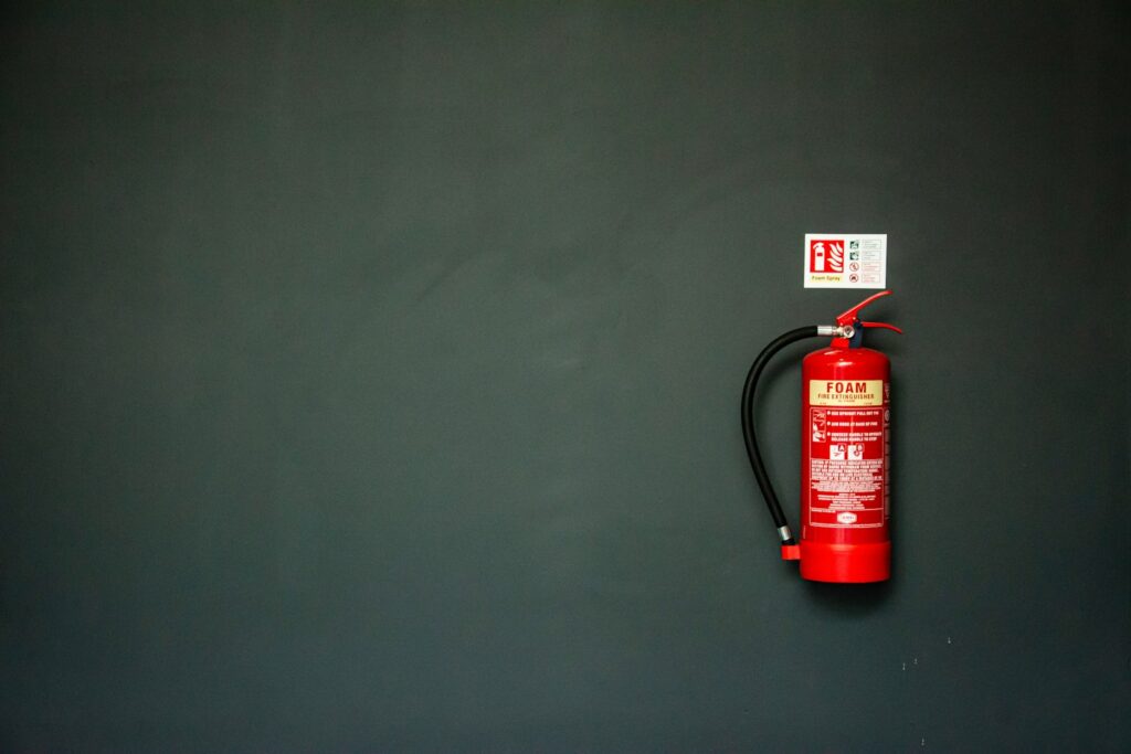 red fire extinguisher on gray wall