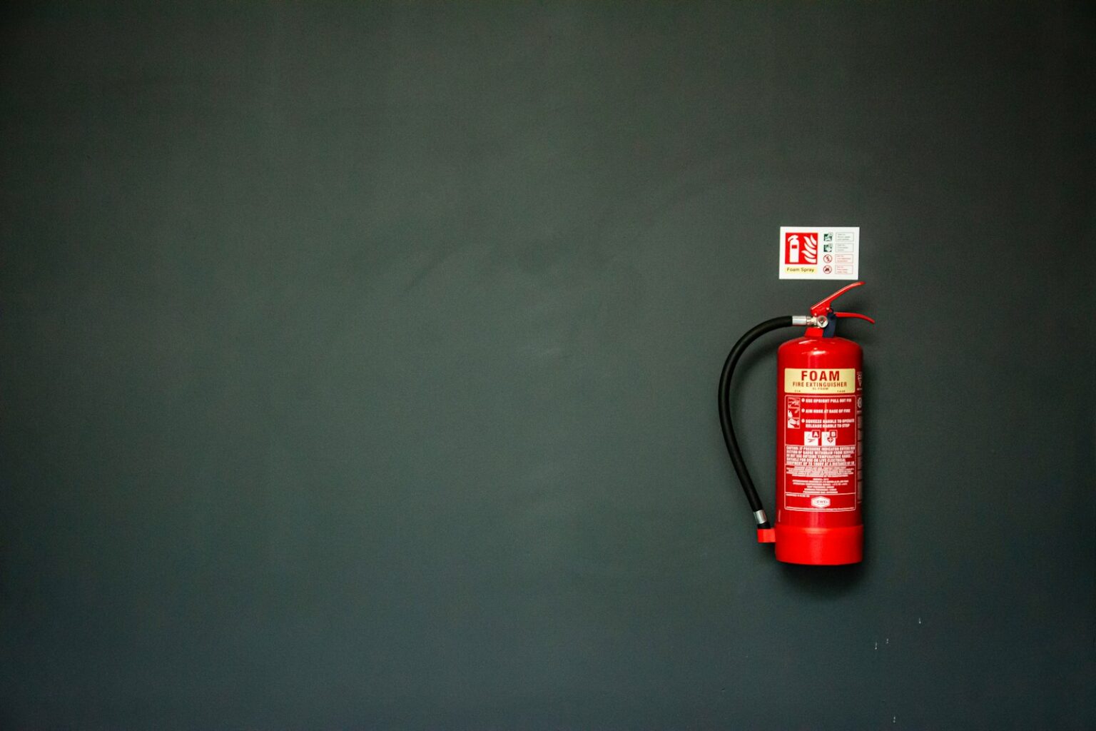 red fire extinguisher on gray wall